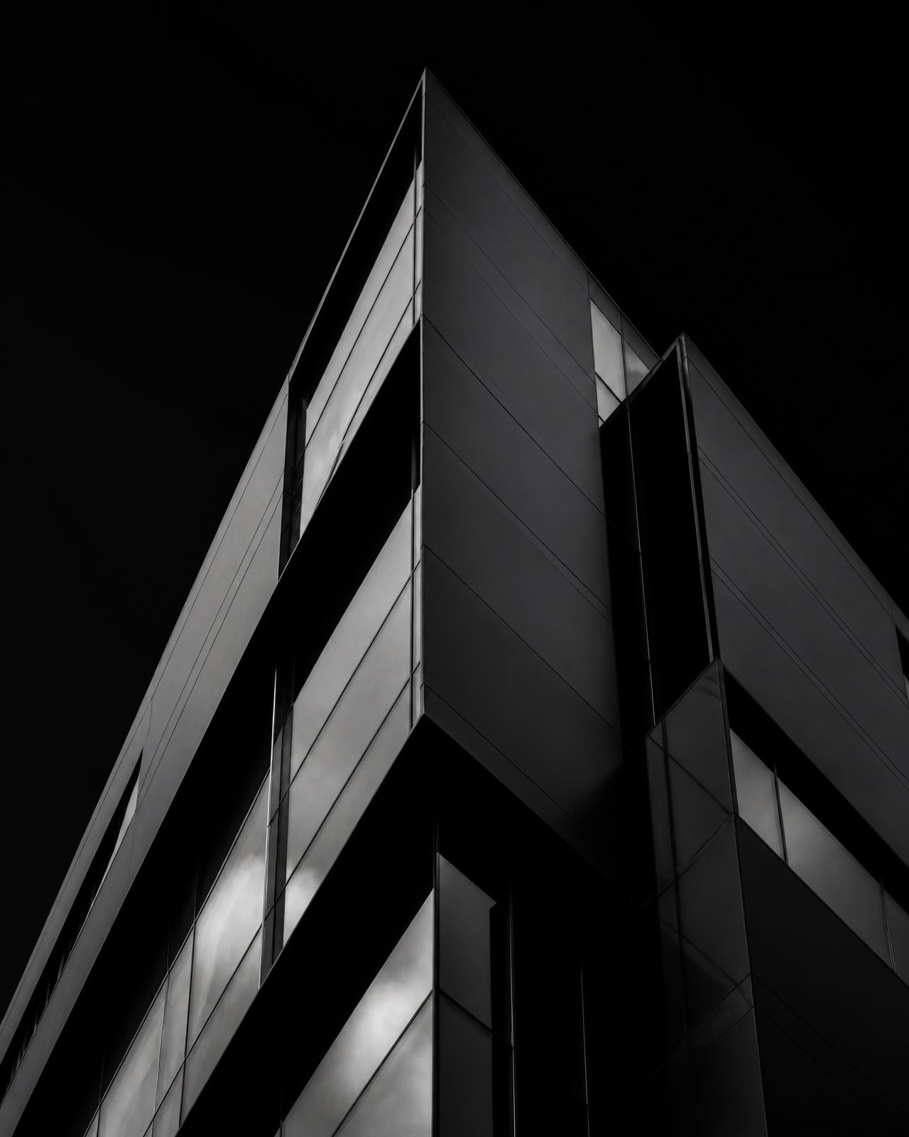 Mörk geometrisk arkitektur med skarpa ytor i stål och glas